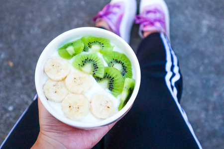 Young women is resting and eating a healthy fruit yogurt after a workout.Fitness and healthy lifestyle concept.の写真素材