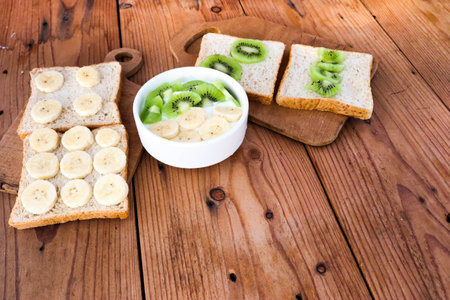 Tropical fruit kiwi, banana bowl with yogurt and Wholegrain bread slices with kiwi,banana, healthy vegetarian food and lifestyle concept.の写真素材