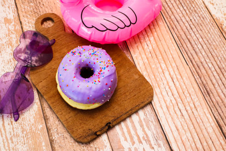 Glazed donuts on wooden tray with sunglasses.の写真素材