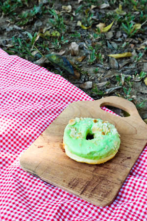 Glazed donuts on wooden tray in garden.の写真素材