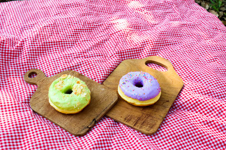 Picnic concept,Glazed donuts on wooden tray in garden.の写真素材
