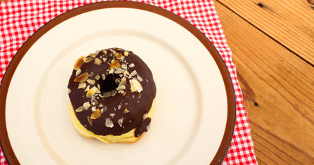 Chocolate Donuts with almonds on white plate .の写真素材