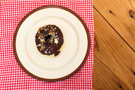 Chocolate Donuts with almonds on white plate .の写真素材