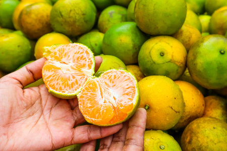 Fresh oranges on hand at the farmers market.の写真素材