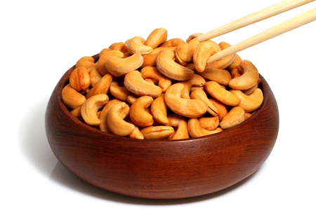 Cashew in wooden bowl and Chopsticks on white backgroundの写真素材
