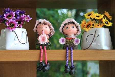 Cute ceramic dolls with pink, purple and yellow flowersの写真素材