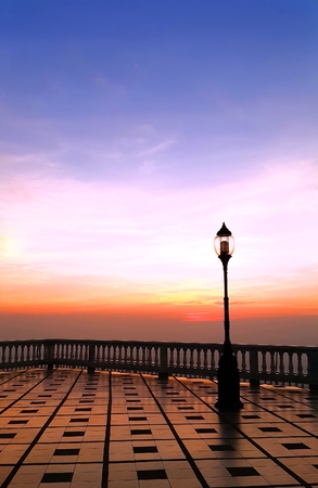 Textured of stone pavement floor and lamp post during colorful morningの写真素材