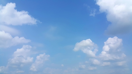 Clear blue sky with soft white clouds