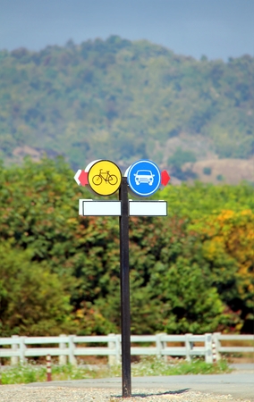 Traffic or road signs, Yellow bike and blue car with red direction signsの写真素材