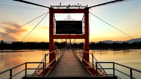 Tak, Thailand, Nov05, 2015 : 200 year Rattanakosin Sompoch bridge (hanging bridge) across the ping River during colorful twilight sky. Tak province, Thailandのeditorial素材