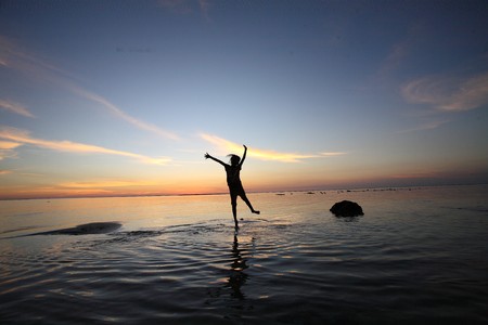 Young female is jump on the beachの写真素材