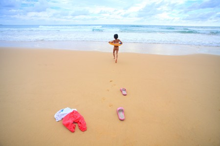 Walking girl on sandy beach 
