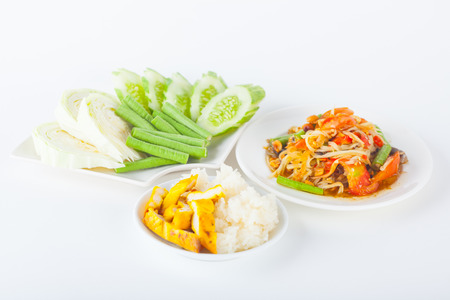 Papaya salad (som tum Thai) with sticky rice and grilled chicken on white paper backgroundの写真素材