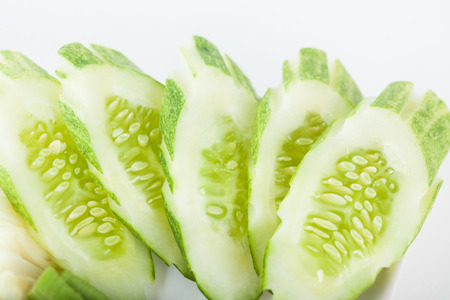 Fresh cucumber slice on dish with white paper backgroundの写真素材