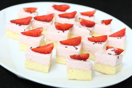 Piece of fruit strawberry cake with icing on white isolated backgroundの写真素材