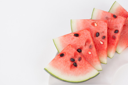 Cut watermelon on plate with white paper backgroundの写真素材