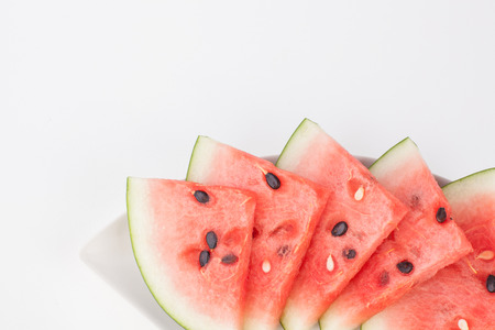 Cut watermelon on plate with white paper backgroundの写真素材