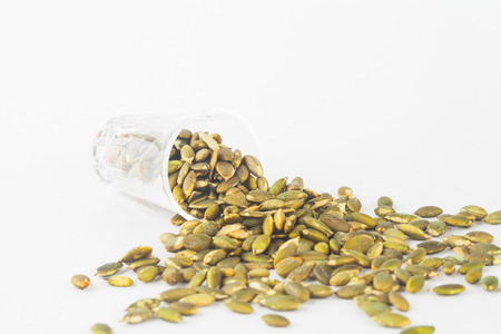 Pumpkin seeds close up in glass on white blackgroudの写真素材