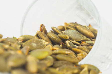 Pumpkin seeds close up in glass on white blackgroudの写真素材