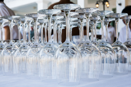 Empty wine glasses arranged in row, setup for wedding ceremony.