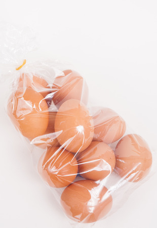 Eggs in a plastic bag on white paper backgroundの写真素材