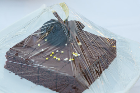 Chocolate brownie cake on plasstic warp set for wedding dinnerの写真素材