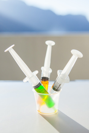Syringe with syrup medicine use to feed for kids on table in hospital room.の写真素材