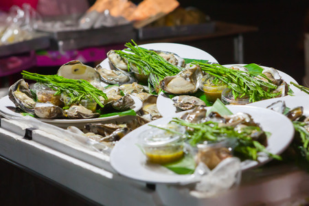 Fresh oysters in a white plate at night market,Thailand