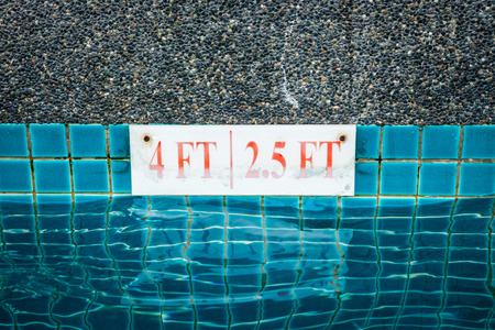pool depth sign at the edge of the swimming poolの写真素材