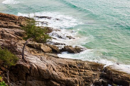 view of sea waves hitting rocks on the beach in Phuket, Thailandの写真素材