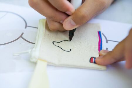 Child's hand painting on cloth with colorful pens.の写真素材