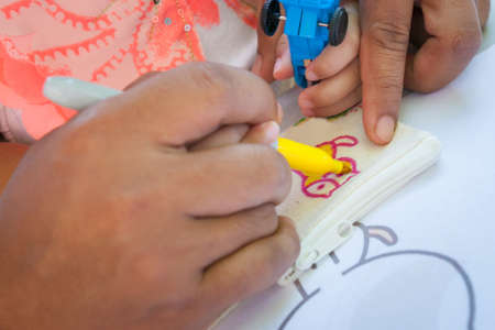 Father's hand teaches children to draw and paint.の写真素材