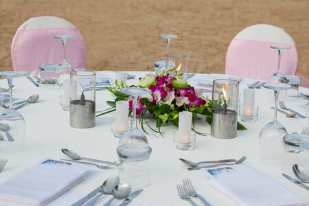Set the table for dinner on the beach.
