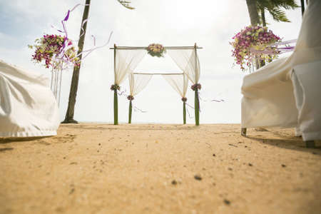 wedding arch decorated on tropical sand beach, outdoor beach wedding setup.の写真素材