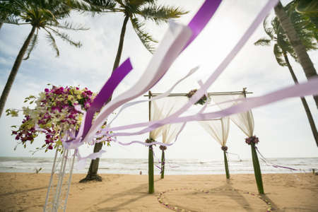 wedding arch decorated on tropical sand beach, outdoor beach wedding setup.の写真素材