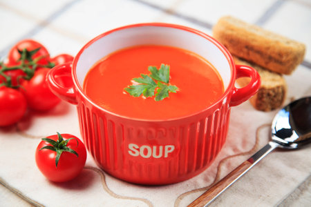 Lunch table setting with tomato cream soup, crackers and tomatoes.の写真素材