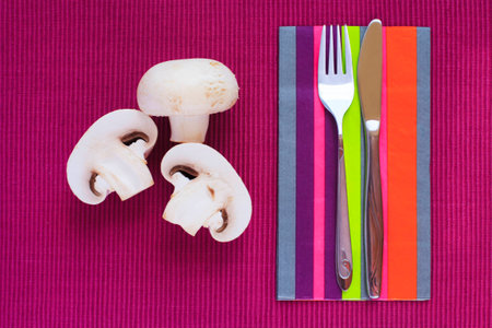Fresh mushrooms ready to be served or prepared for a healthy eating lifestyle, fork and knife placed...