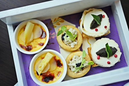 A colorful and delicious set of afternoon tea party in lavender theme: scones with clotted cream and...