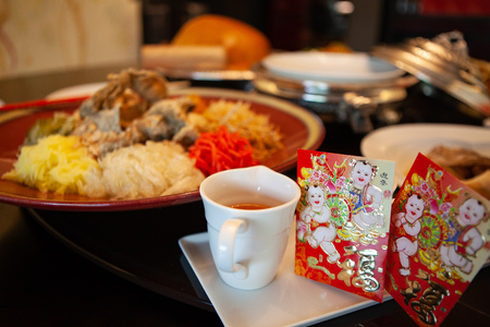 Yusheng or Prosperity Toss is a Cantonese-style raw fish salad. It is considered a symbol of abundance, a cultural activity dish for Chinese New Year. Chinese character on red envelopの写真素材