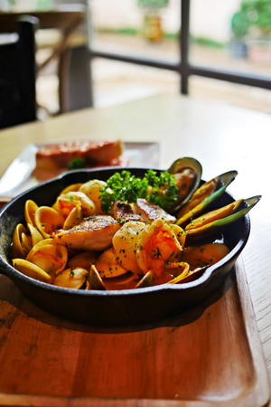 Sizzling hot Bouillabaisse,a traditional ProvenÃ§al fish stew, with lots of seafood such as fish, shrimp, clams, mussels and enhance with saffron in a black cast iron pan served with Rouille.の写真素材