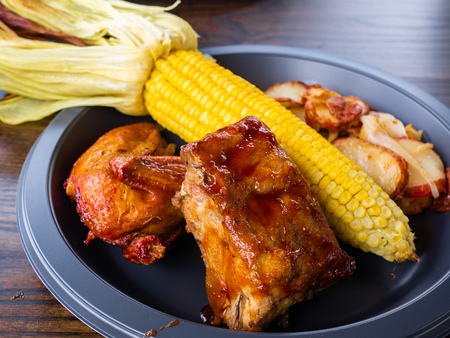 Delicious and appetizing Autumn Holiday barbecued glazed ribs seasoned with a spicy sauce and half...