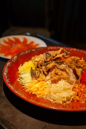Yusheng or Prosperity Toss is a Cantonese-style raw fish salad. It is considered a symbol of abundance for Chinese New Year. Diners will toss the ingredients while sayingの写真素材