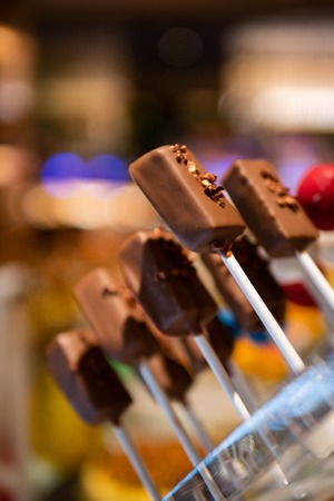 Tasty, delicious cake pop or cake balls coated with chocolate look like lollipop with bokeh lights background. Perfect for romantic date night or celebrate birthday party. Elegant concept.の写真素材