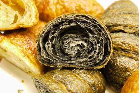 Cross section showing structure of delicious and buttery Charcoal Croissants made by pastry chef. All look very tasty and delightful. Natural light. Close up.の写真素材