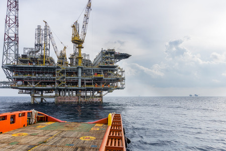A boat sail away from offshore oil rigのeditorial素材