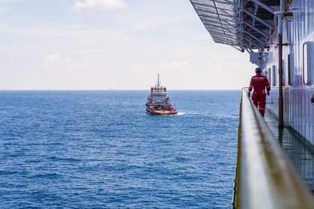 Offshore worker walking on the walkaway on board construction barge monitoring anchor handling operation at Terengganu oilfield, Malaysiaのeditorial素材