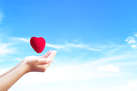 Love and Valentine's Day concept:People open hands holding heart shapeの写真素材