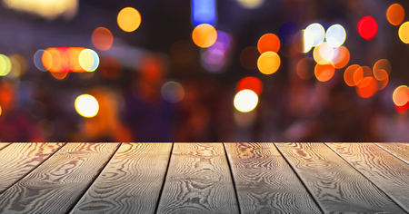Christmas concept: Festive background with light spots and bokeh in front of a empty wooden tableの写真素材