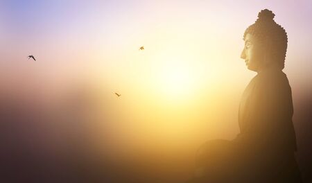 Buddhist concept: Buddha statue on the background of the sunsetの写真素材