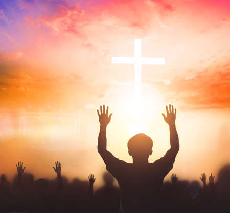 Worship concept: christian people Raise hand over cross on spiritual sky backgroundの写真素材